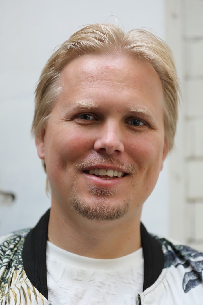 Close-up portrait of a smiling blonde man with facial hair in London. Perfect for lifestyle imagery.